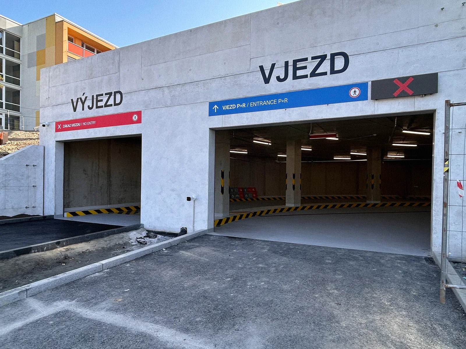 Fasáda P+R Opatov s označením Vjezd a Výjezd a navigačními pásy